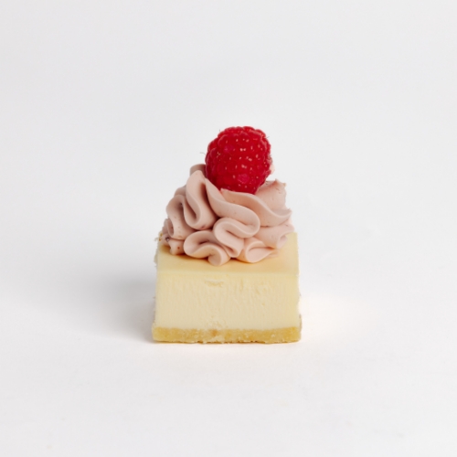 Mini New Yok Cheesecake topped with a swirl of delicate pink frosting and a fresh, bright raspberry