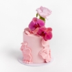 Pink buttercream cake with wavy textured design, topped with fuchsia orchids and a pink rose.
