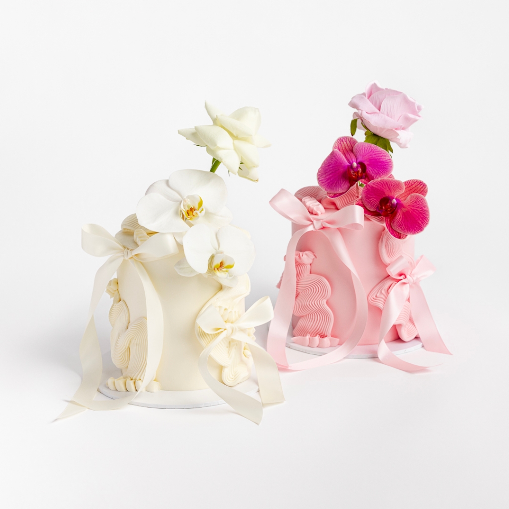 Cream and Pink buttercream cakes with wavy textured design, topped with orchids and a rose.