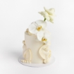 Cream buttercream cake with wavy textured design, topped with white orchids and a white rose.